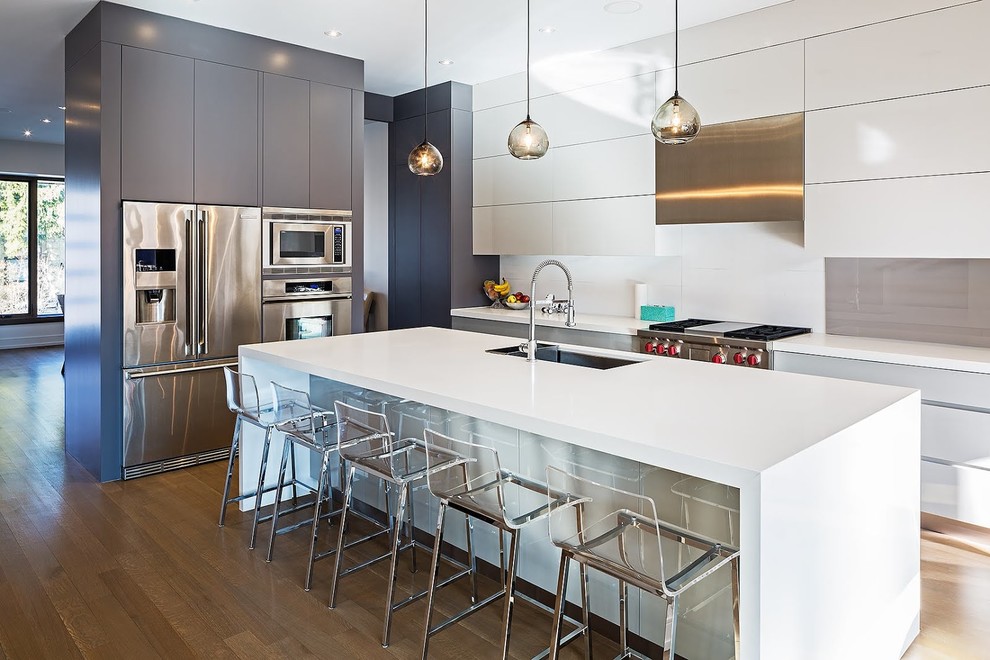 Inspiration for a contemporary l-shaped eat-in kitchen in Toronto with an undermount sink, flat-panel cabinets, white cabinets, white splashback and stainless steel appliances.