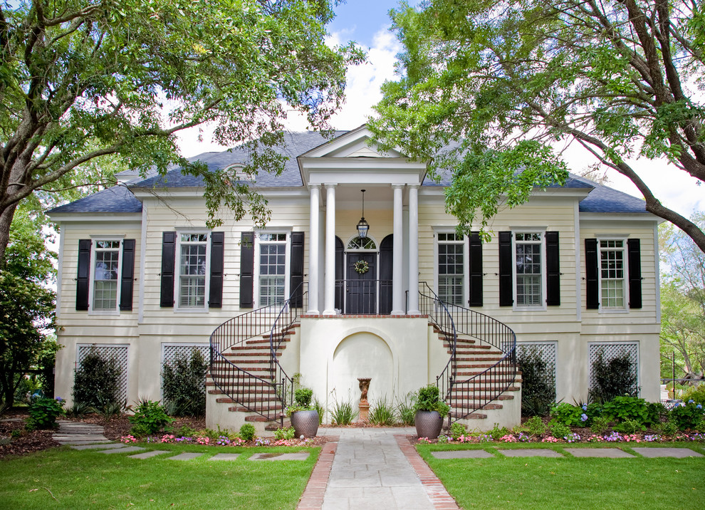 Inspiration for a traditional two-storey beige exterior in Charleston with a hip roof.