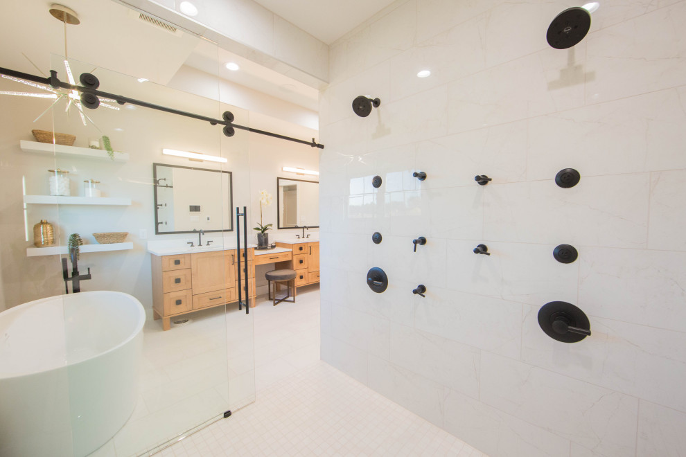 This is an example of an expansive modern master bathroom in Indianapolis with recessed-panel cabinets, brown cabinets, a freestanding tub, a curbless shower, white tile, porcelain tile, beige walls, terra-cotta floors, an undermount sink, quartzite benchtops, white floor, a sliding shower screen, white benchtops, a shower seat, a double vanity, a freestanding vanity and vaulted.