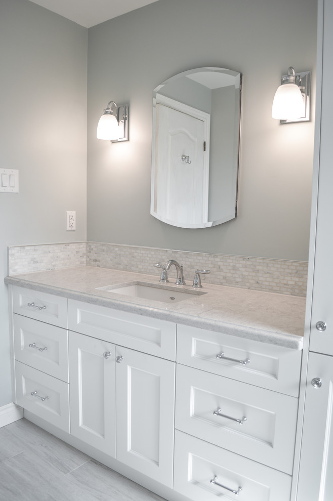 Mid-sized transitional 3/4 white tile and porcelain tile porcelain tile alcove bathtub photo in Toronto with shaker cabinets, white cabinets, a two-piece toilet, blue walls, an undermount sink and quartz countertops