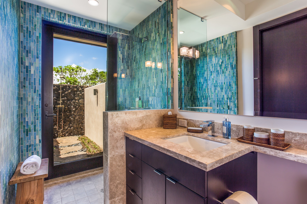 This is an example of a small contemporary 3/4 bathroom in Hawaii with flat-panel cabinets, dark wood cabinets, granite benchtops, an open shower, blue tile, glass tile, white walls, ceramic floors, an undermount sink and an open shower.