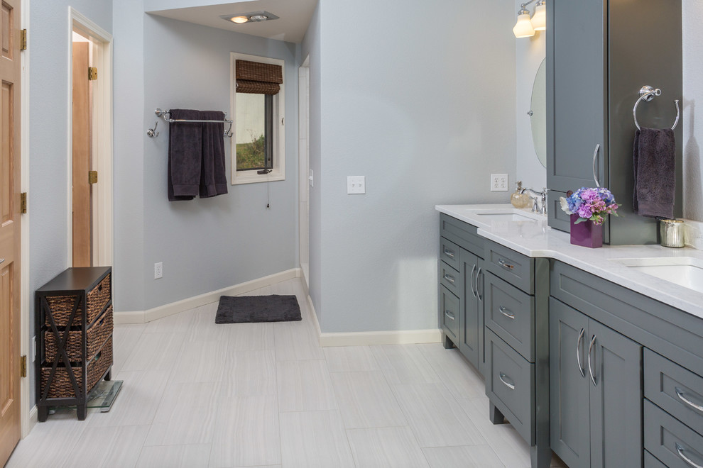 Inspiration for a mid-sized transitional master white tile and porcelain tile porcelain tile freestanding bathtub remodel with an undermount sink, shaker cabinets, gray cabinets, quartz countertops, a one-piece toilet and gray walls