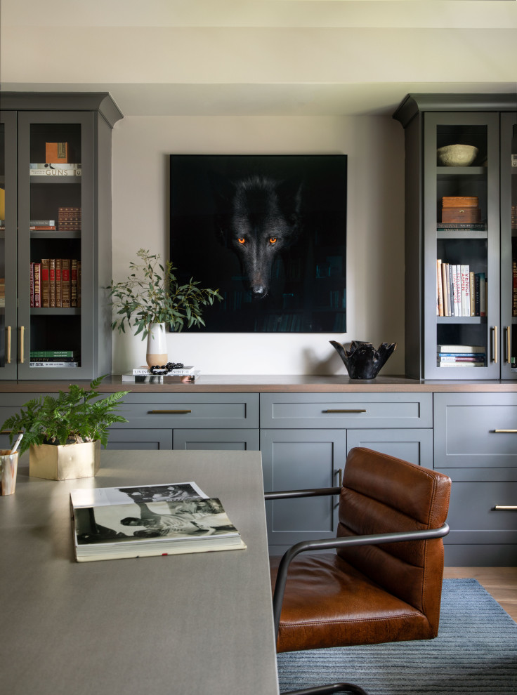 Inspiration for a large transitional study room in Houston with grey walls, medium hardwood floors, a freestanding desk and brown floor.