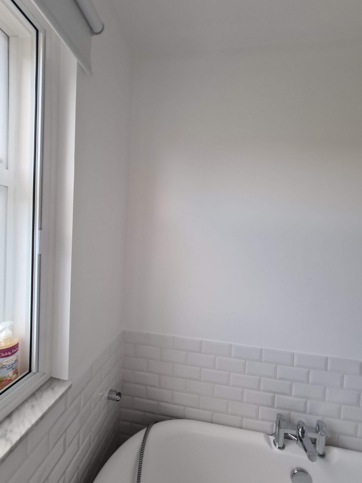Foto på ett stort funkis vit badrum för barn, med möbel-liknande, bruna skåp, ett fristående badkar, en öppen dusch, en vägghängd toalettstol, vit kakel, keramikplattor, vita väggar, klinkergolv i porslin, ett nedsänkt handfat, granitbänkskiva, vitt golv och med dusch som är öppen