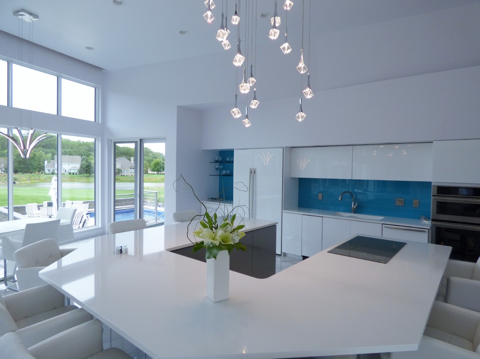 This is an example of an expansive contemporary u-shaped eat-in kitchen in Other with an undermount sink, flat-panel cabinets, grey cabinets, quartz benchtops, blue splashback, glass tile splashback, stainless steel appliances, marble floors and with island.