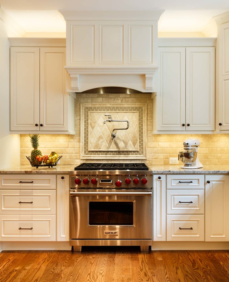 Large transitional medium tone wood floor and brown floor eat-in kitchen photo in DC Metro with a farmhouse sink, white cabinets, beige backsplash, stainless steel appliances and beige countertops