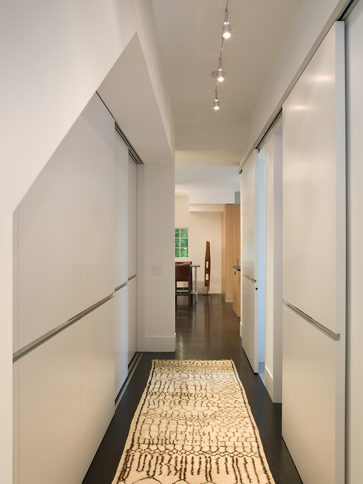 This is an example of a mid-sized contemporary hallway in San Francisco with white walls and dark hardwood floors.