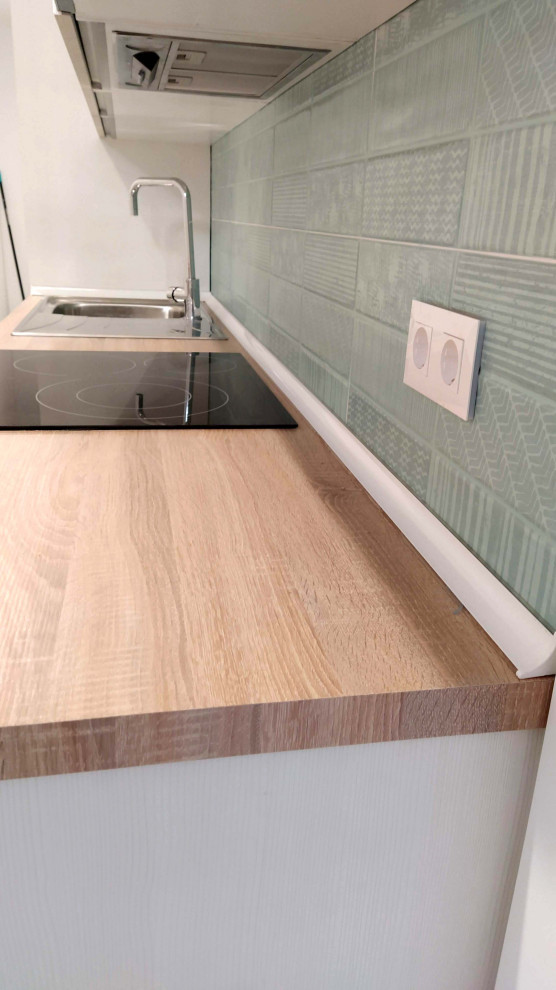 Ejemplo de cocina lineal nórdica pequeña abierta sin isla con fregadero de un seno, armarios con paneles lisos, puertas de armario blancas, encimera de madera, salpicadero gris, salpicadero de azulejos de cerámica, electrodomésticos de acero inoxidable, suelo de mármol, suelo gris y encimeras marrones