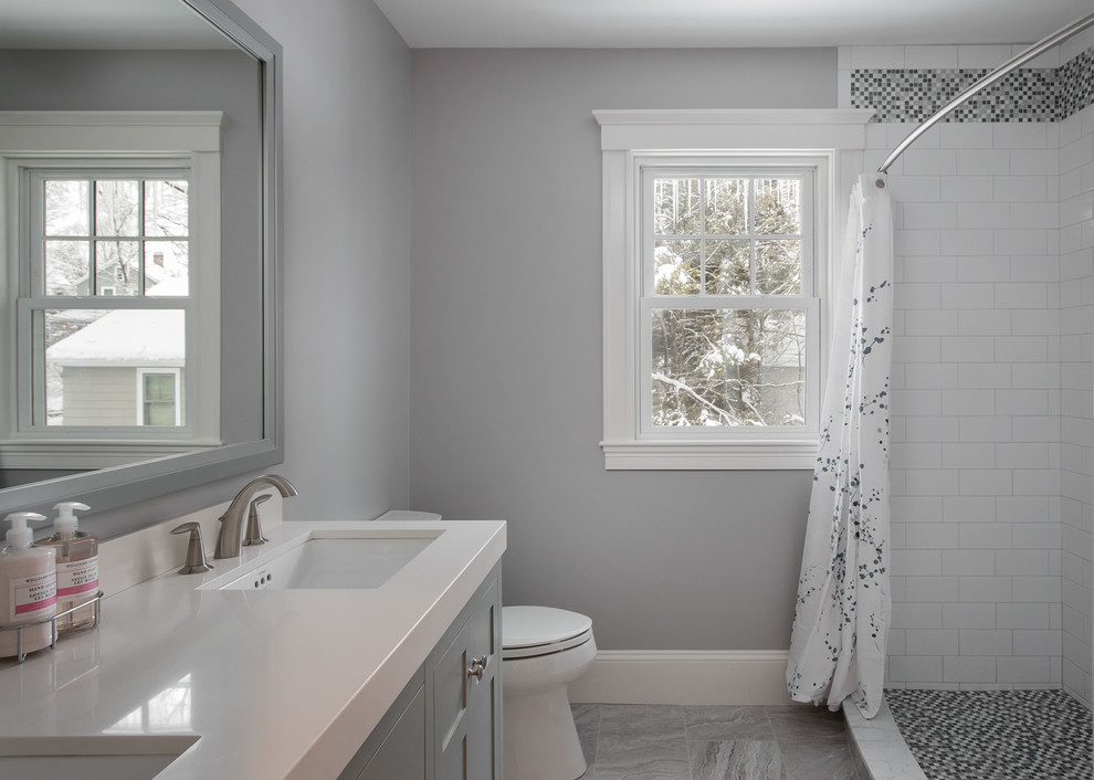Design ideas for a mid-sized traditional bathroom in Boston with shaker cabinets, grey cabinets, an alcove shower, multi-coloured tile, ceramic tile, grey walls, porcelain floors and solid surface benchtops.