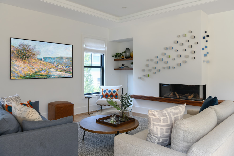 Inspiration for a large contemporary open concept family room in DC Metro with white walls, light hardwood floors, a standard fireplace and a wall-mounted tv.