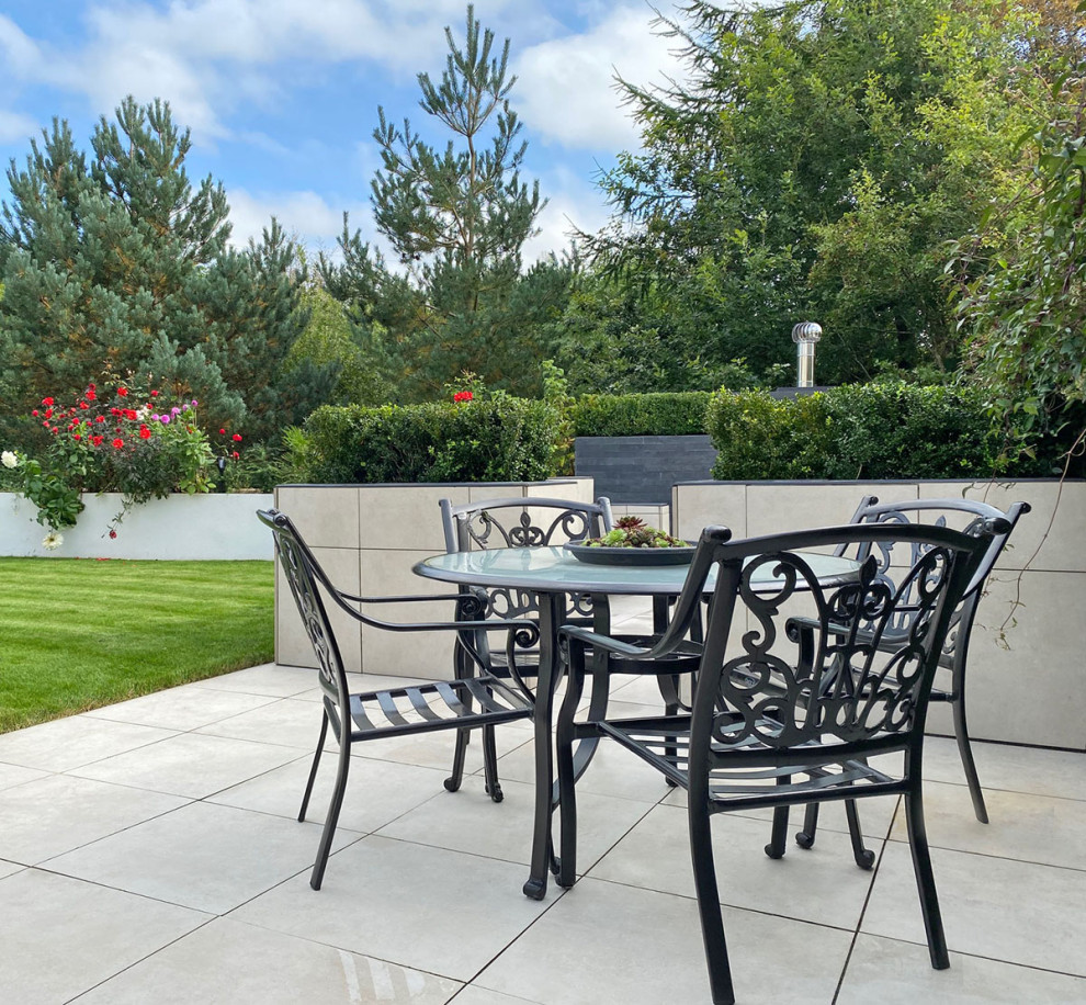 Inspiration for a medium sized contemporary back patio in Hertfordshire with natural stone paving.