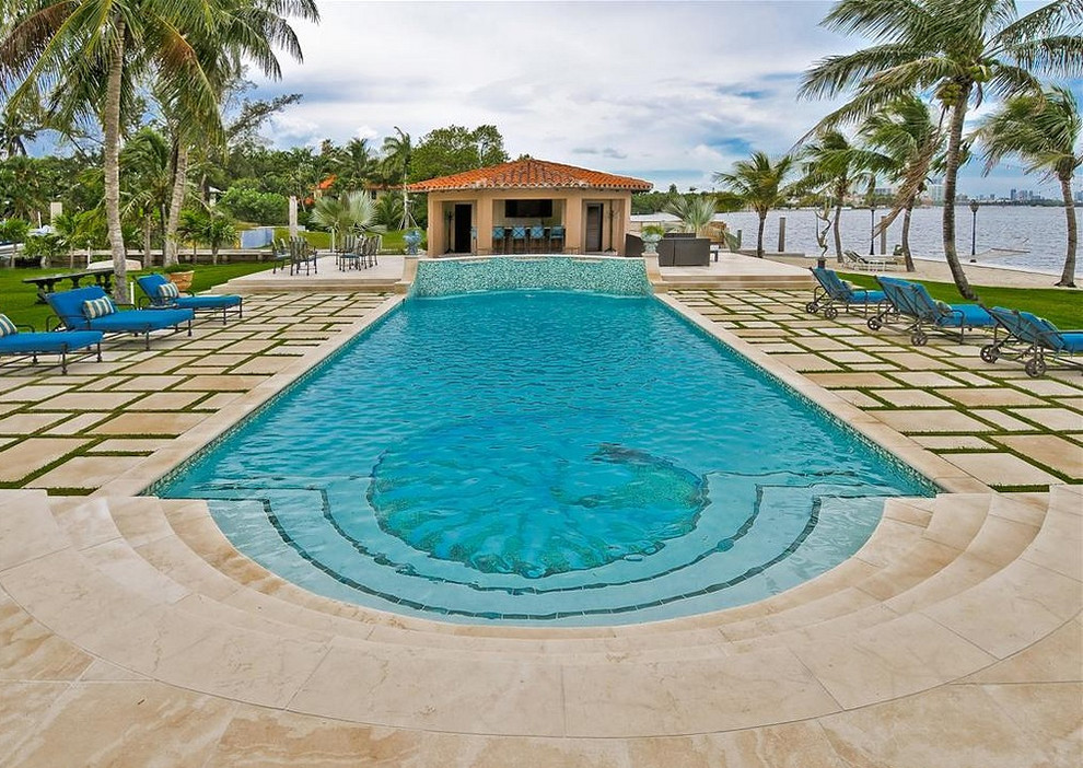 Inspiration for a large mediterranean backyard rectangular pool in Miami with a water feature and tile.