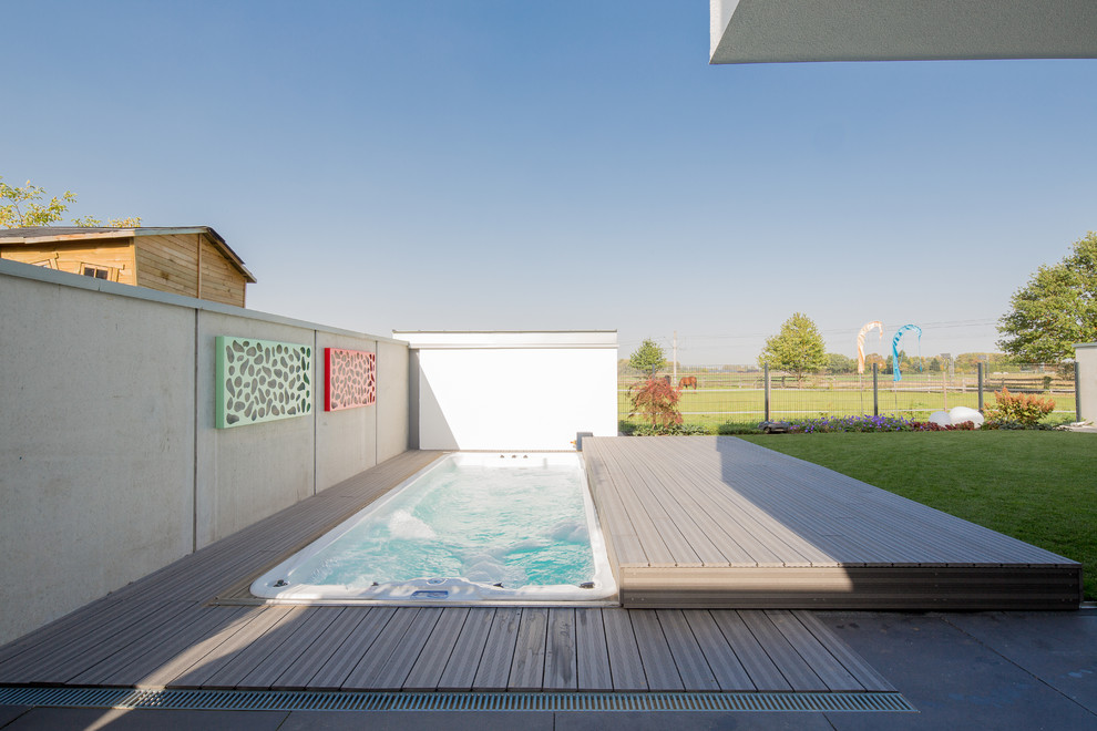 Design ideas for a small contemporary backyard rectangular aboveground pool in Dusseldorf with a hot tub and concrete slab.