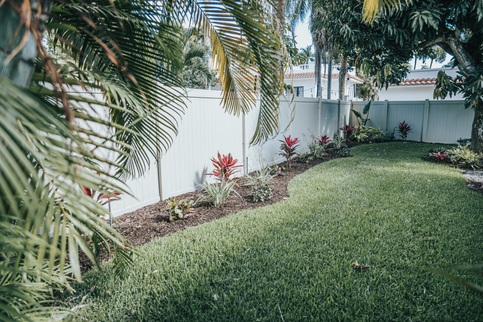This is an example of a tropical front yard garden in Other with with flowerbed.