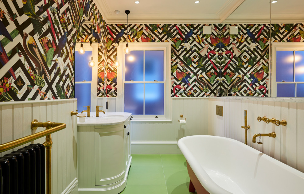 Photo of an eclectic bathroom in Cambridgeshire with a freestanding bath, a walk-in shower, a wall mounted toilet, porcelain flooring, green floors, a hinged door, a single sink and wallpapered walls.