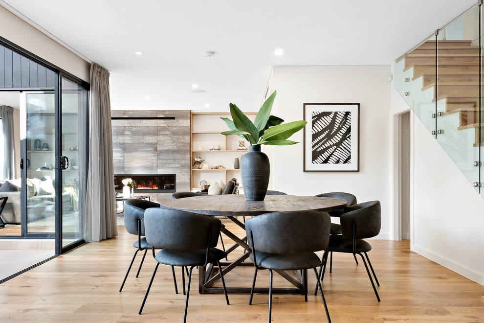 Photo of a contemporary open plan dining in Sydney with white walls, medium hardwood floors and brown floor.