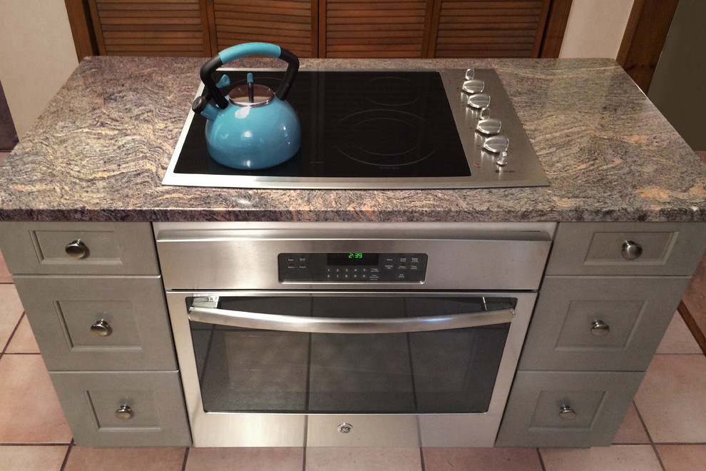 Example of a mid-sized transitional l-shaped ceramic tile eat-in kitchen design in Boston with an undermount sink, shaker cabinets, gray cabinets, granite countertops, gray backsplash, glass tile backsplash, stainless steel appliances and an island