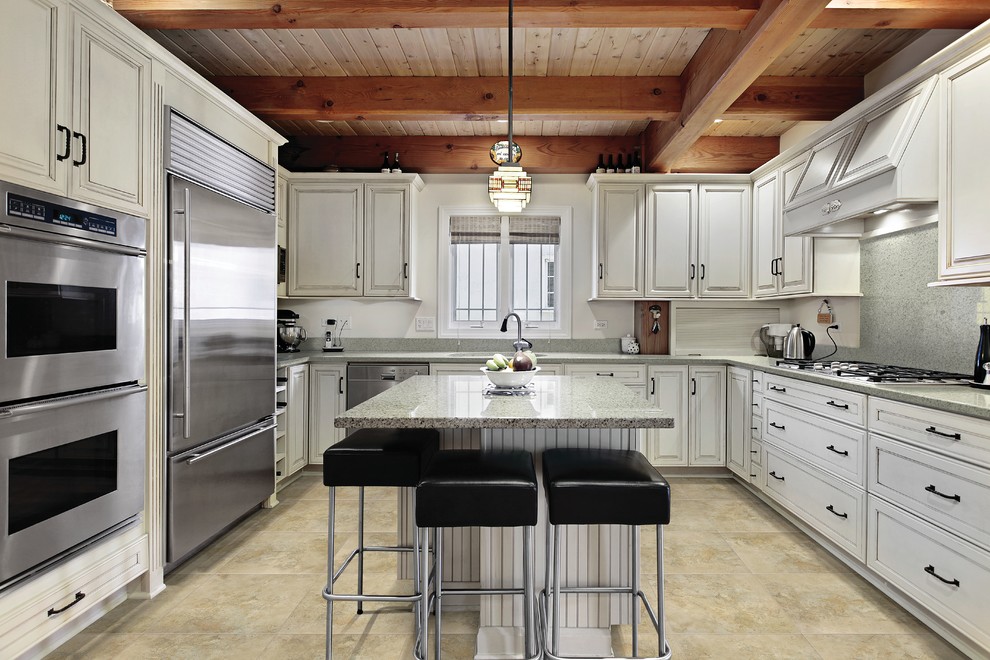 Photo of a transitional u-shaped kitchen in Philadelphia with raised-panel cabinets, white cabinets, stainless steel appliances and with island.