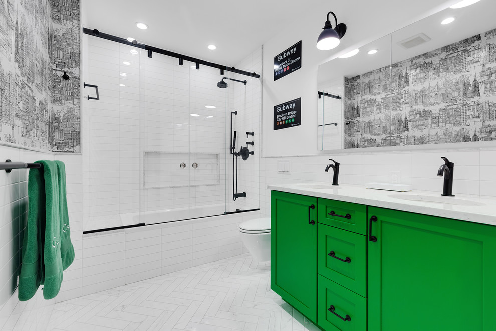 Photo of a transitional 3/4 bathroom in New York with shaker cabinets, green cabinets, an alcove tub, a shower/bathtub combo, a wall-mount toilet, white tile, subway tile, white walls, an undermount sink, white floor, a sliding shower screen and white benchtops.