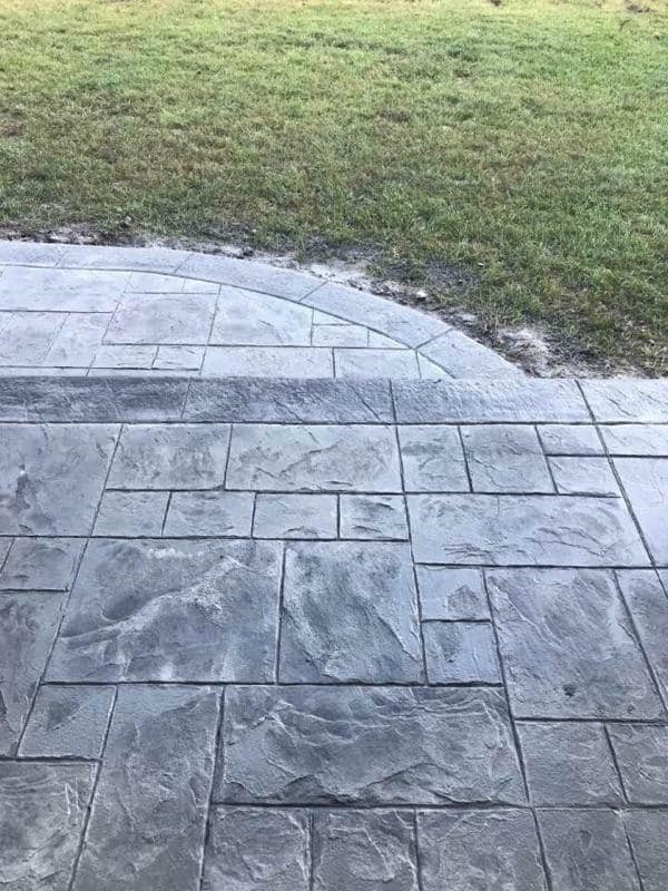 This is an example of a large backyard patio in Other with stamped concrete.