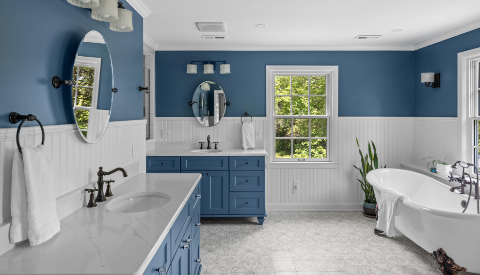 Claw-foot bathtub - transitional gray floor, double-sink and wainscoting claw-foot bathtub idea in Milwaukee with shaker cabinets, blue cabinets, blue walls, an undermount sink, white countertops and a freestanding vanity