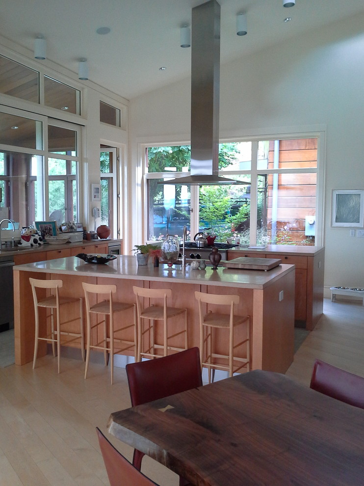 Example of a mid-sized minimalist u-shaped light wood floor and brown floor open concept kitchen design in Bridgeport with medium tone wood cabinets, stainless steel appliances, an island, an undermount sink, recessed-panel cabinets and solid surface countertops