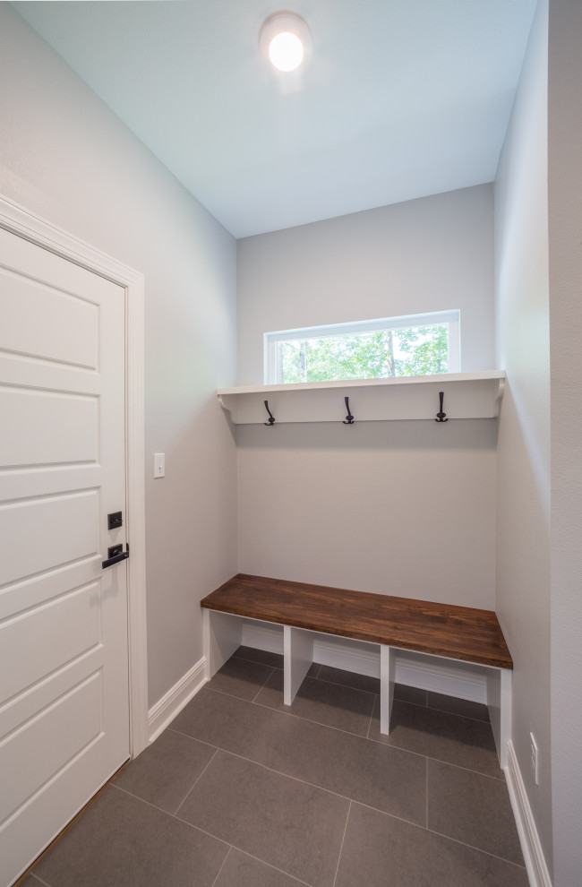 Example of a mid-sized classic porcelain tile and gray floor mudroom design with white walls