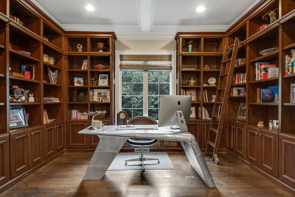 This is an example of a traditional study room in Chicago with beige walls, dark hardwood floors, a freestanding desk and brown floor.