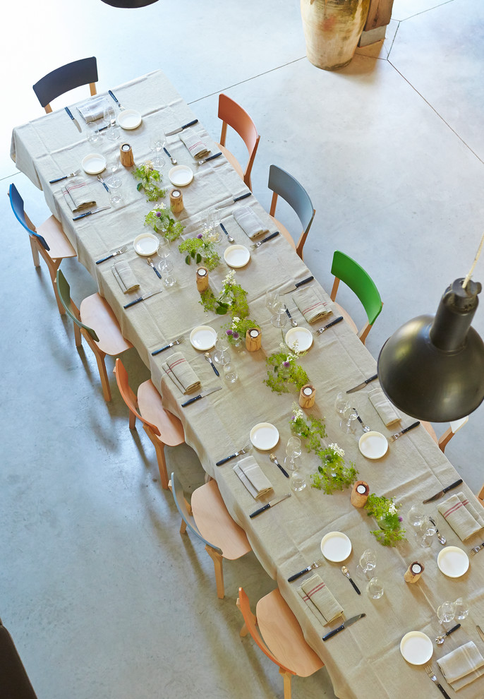 This is an example of a large contemporary dining room in Melbourne with white walls and concrete floors.