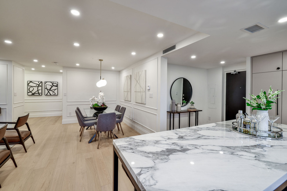 Inspiration for a mid-sized contemporary open plan dining in Toronto with white walls, light hardwood floors, a standard fireplace, a concrete fireplace surround, beige floor and wood walls.