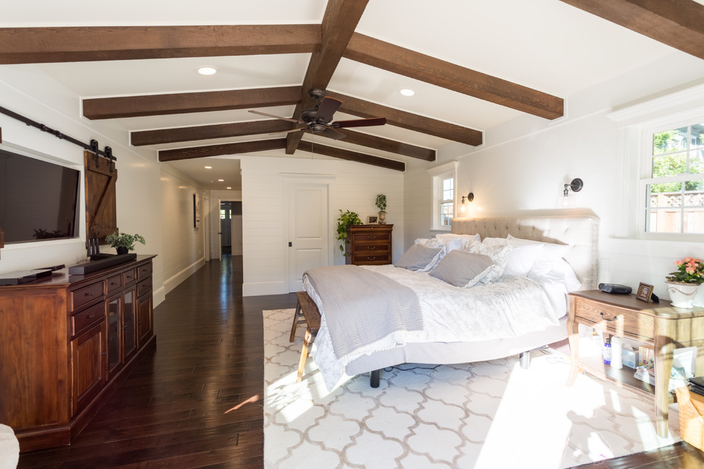 Country master bedroom in San Francisco with white walls, dark hardwood floors and brown floor.