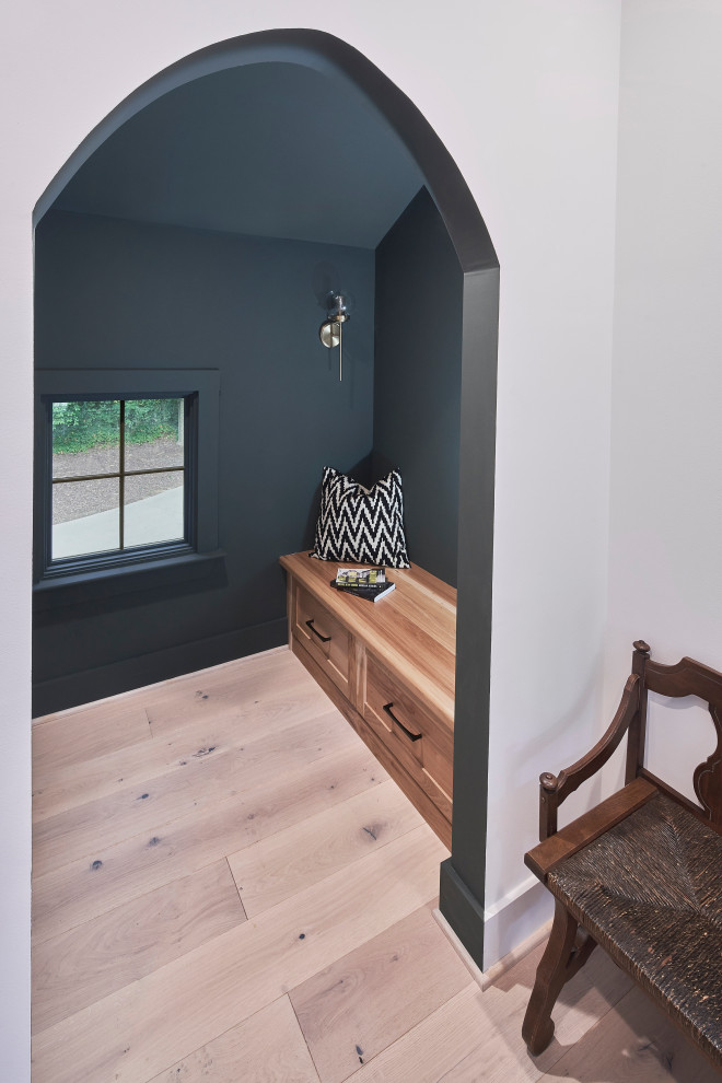 Inspiration for a small scandinavian gender-neutral walk-in wardrobe in Charlotte with shaker cabinets, light wood cabinets, light hardwood floors and brown floor.