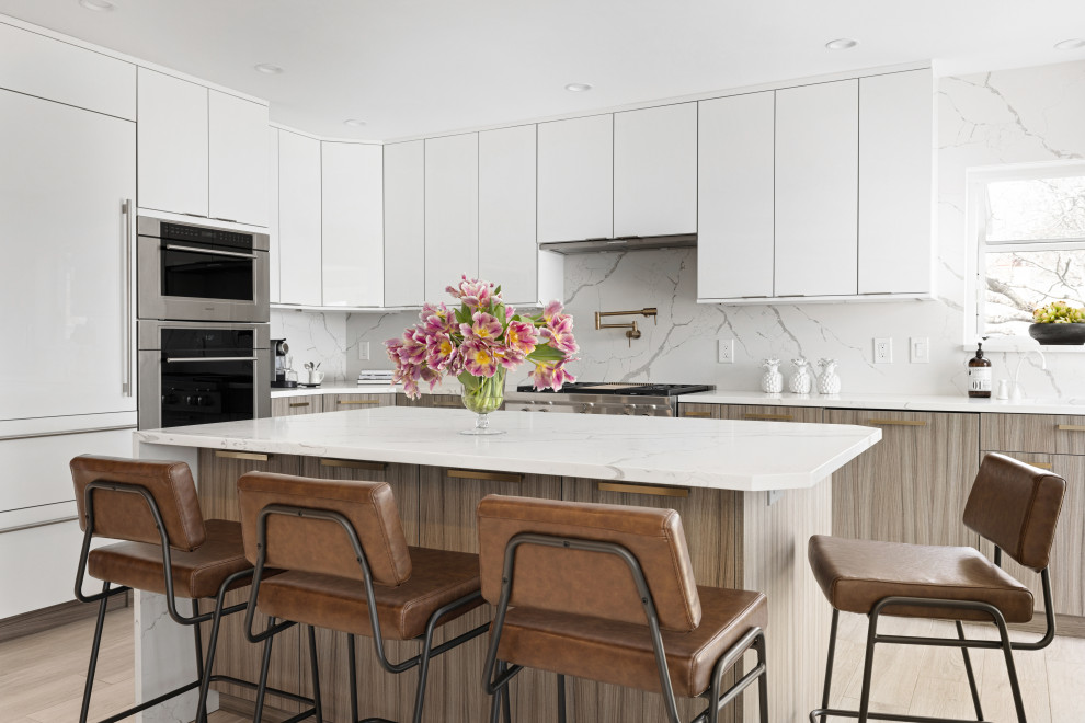 Idéer för ett modernt vit l-kök, med en undermonterad diskho, släta luckor, vita skåp, bänkskiva i kvarts, vitt stänkskydd, rostfria vitvaror och en köksö