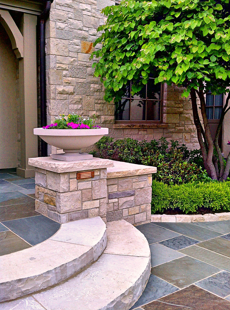 This is an example of a traditional front yard garden in Chicago with a garden path and natural stone pavers.