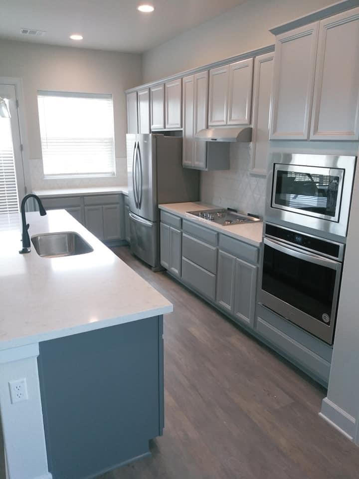 Kitchen pantry - mid-sized transitional l-shaped medium tone wood floor and brown floor kitchen pantry idea in Austin with a single-bowl sink, flat-panel cabinets, gray cabinets, quartz countertops, an island and white countertops