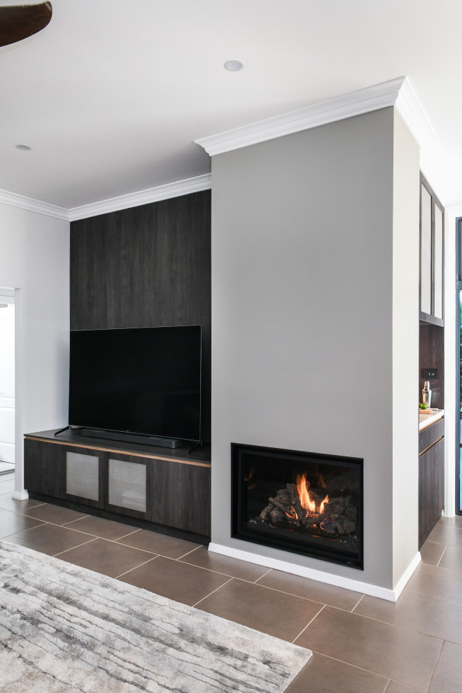 This is an example of a medium sized contemporary open plan living room in Sydney with black walls, ceramic flooring, a standard fireplace, a plastered fireplace surround and a freestanding tv.