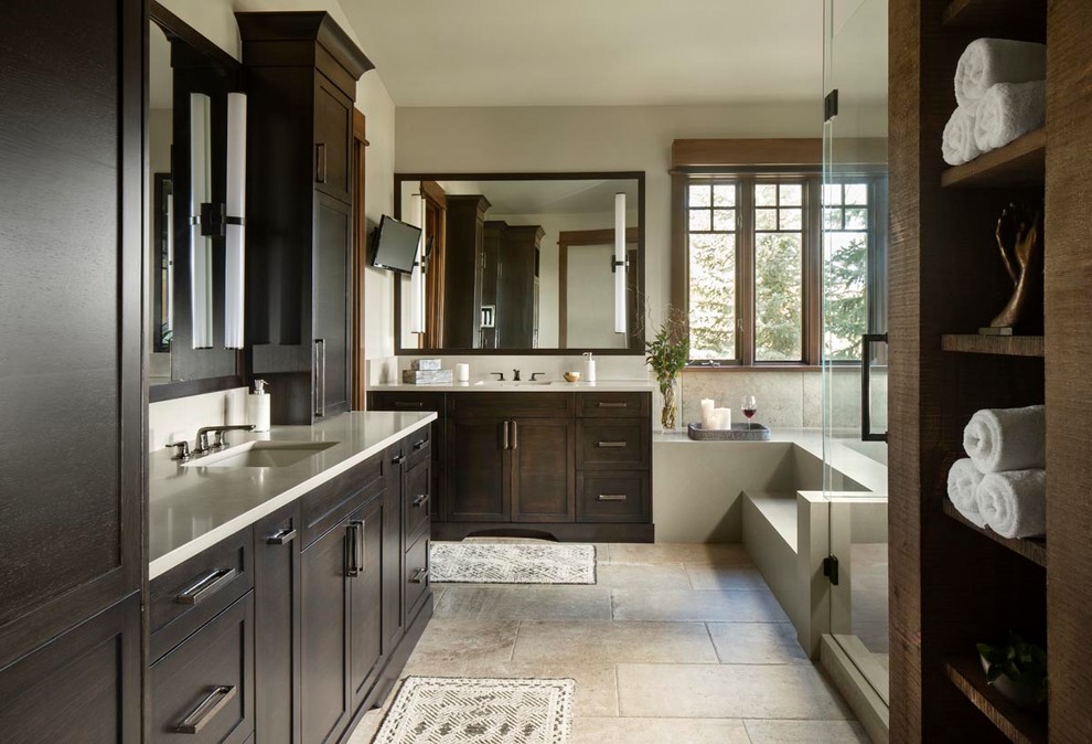 Country bathroom in Other with shaker cabinets, dark wood cabinets, a corner tub, gray tile, beige walls, an undermount sink, beige floor, a hinged shower door and white benchtops.