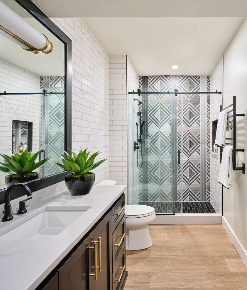 Medium sized traditional family bathroom in Omaha with shaker cabinets, black cabinets, an alcove shower, a two-piece toilet, white tiles, ceramic tiles, white walls, porcelain flooring, a submerged sink, engineered stone worktops, multi-coloured floors, a sliding door, white worktops, a single sink and a built in vanity unit.