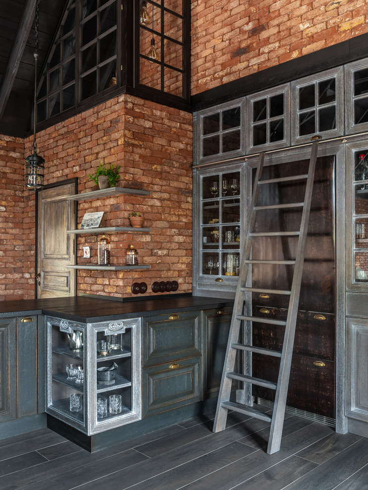 Industrial kitchen in Other with raised-panel cabinets, grey cabinets, brown splashback, brick splashback, coloured appliances and grey floor.