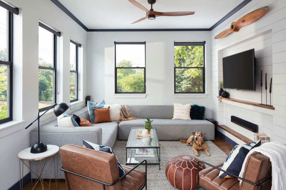 Example of a mid-sized transitional enclosed medium tone wood floor, brown floor, tray ceiling and shiplap wall living room design in Denver with white walls, no fireplace and a wall-mounted tv
