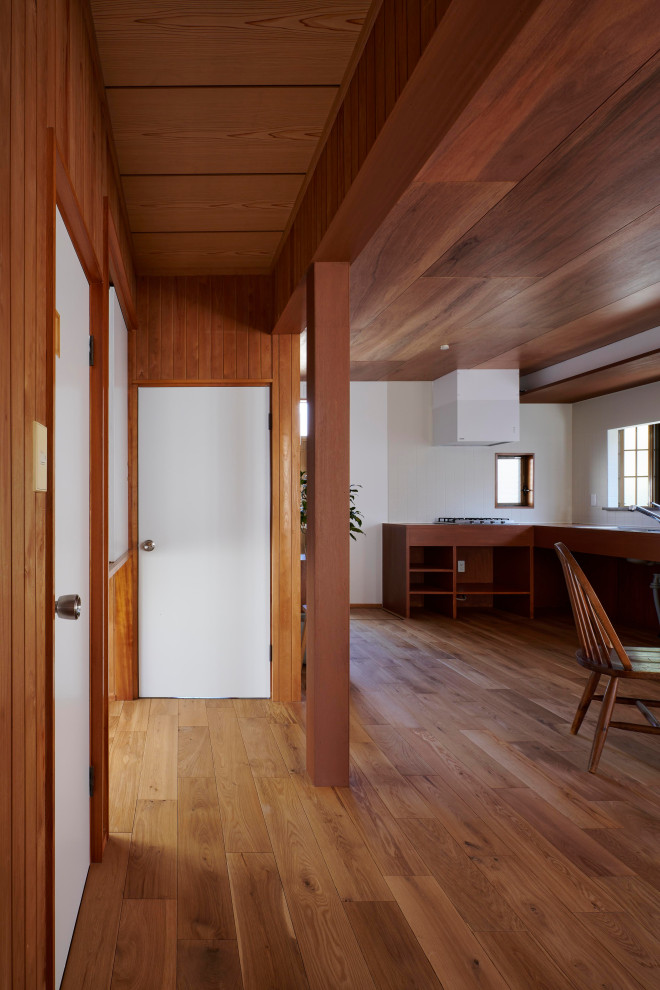 Modelo de recibidores y pasillos de tamaño medio con paredes marrones, suelo de madera en tonos medios, suelo marrón, madera y madera