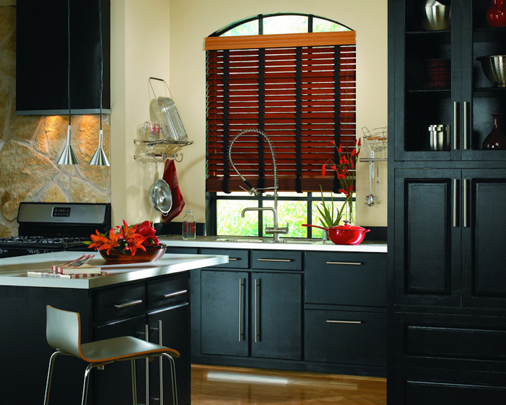 Mid-sized transitional light wood floor home design photo in Indianapolis with a drop-in sink, raised-panel cabinets, black cabinets, stainless steel appliances and an island