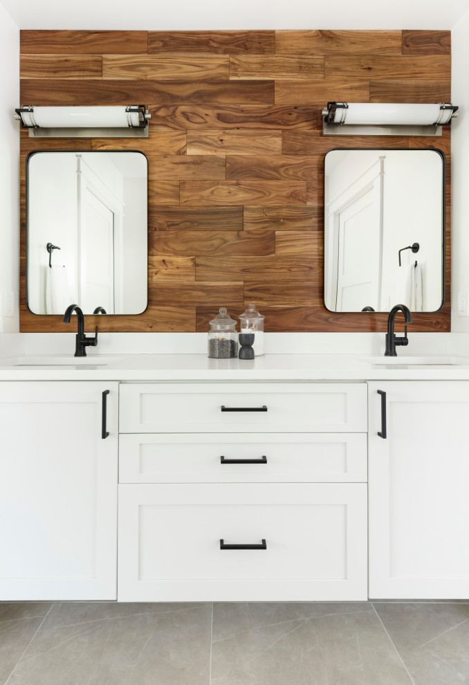 Photo of a mid-sized country bathroom in Portland with flat-panel cabinets, medium wood cabinets, an alcove tub, an alcove shower, a two-piece toilet, white tile, ceramic tile, white walls, porcelain floors, an undermount sink, engineered quartz benchtops, grey floor, a sliding shower screen, white benchtops, a double vanity, a floating vanity, an enclosed toilet and wood walls.