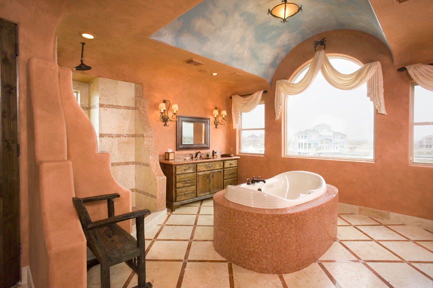 Expansive mediterranean master bathroom in Houston with recessed-panel cabinets, medium wood cabinets, marble benchtops, orange tile, stone tile, a freestanding tub, an alcove shower, a one-piece toilet, an undermount sink, orange walls and travertine floors.
