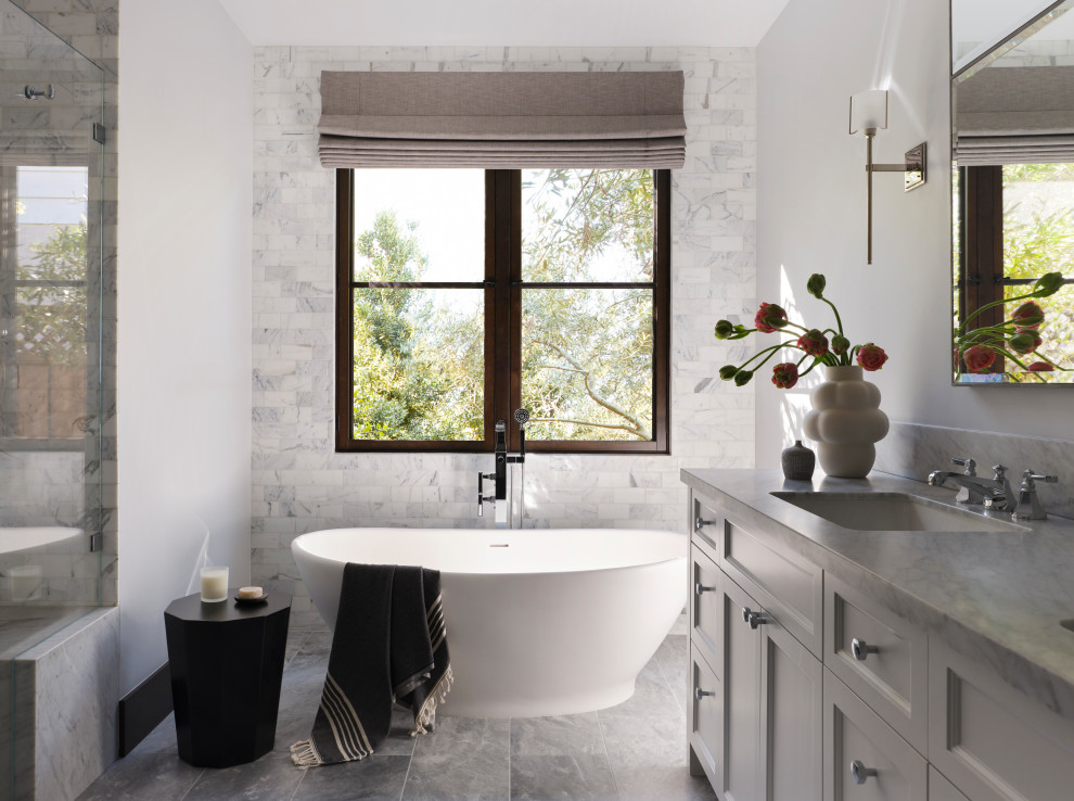 Esempio di una stanza da bagno padronale mediterranea con vasca freestanding, pavimento in marmo, top in marmo e due lavabi