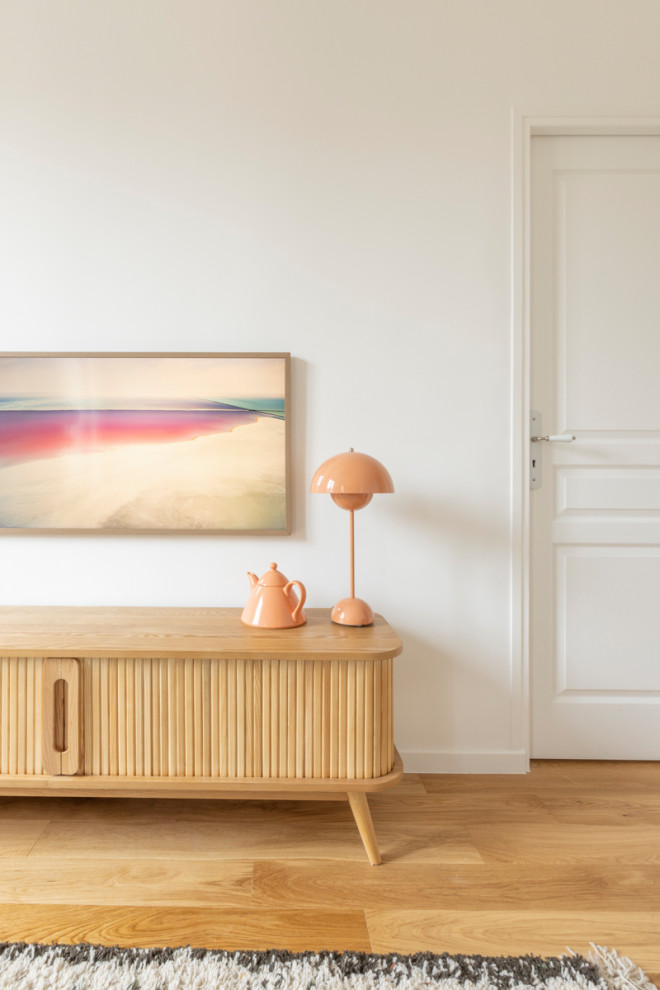 На фото: гостиная комната среднего размера, в белых тонах с отделкой деревом в скандинавском стиле с светлым паркетным полом и телевизором на стене с