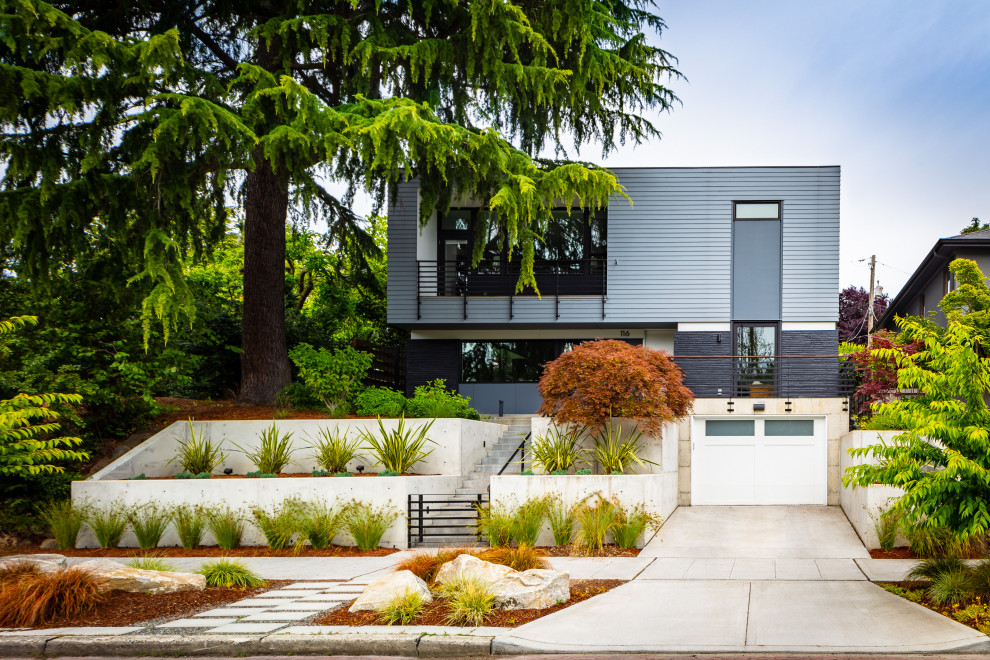 Inspiration for a mid-sized modern three-storey grey house exterior in Seattle with concrete fiberboard siding and a flat roof.