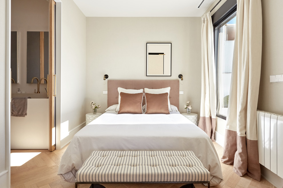 This is an example of a contemporary bedroom in Madrid with beige walls, light hardwood floors and beige floor.