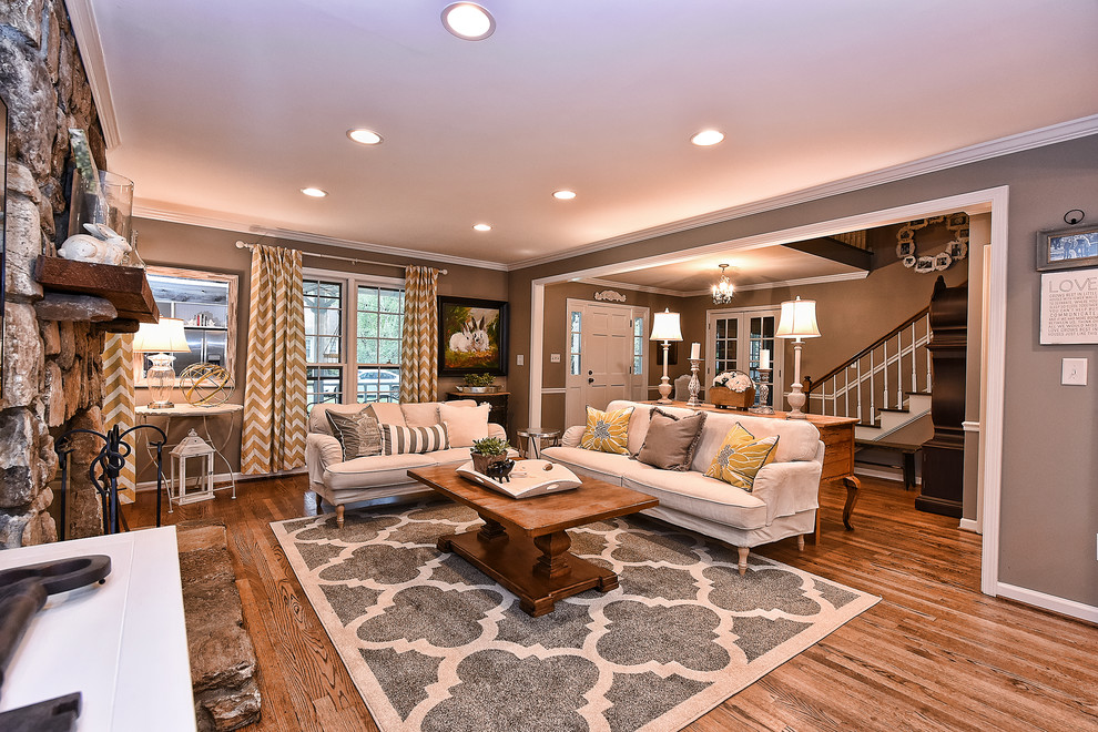 Design ideas for a transitional formal open concept living room in Charlotte with grey walls, medium hardwood floors, a standard fireplace and a stone fireplace surround.