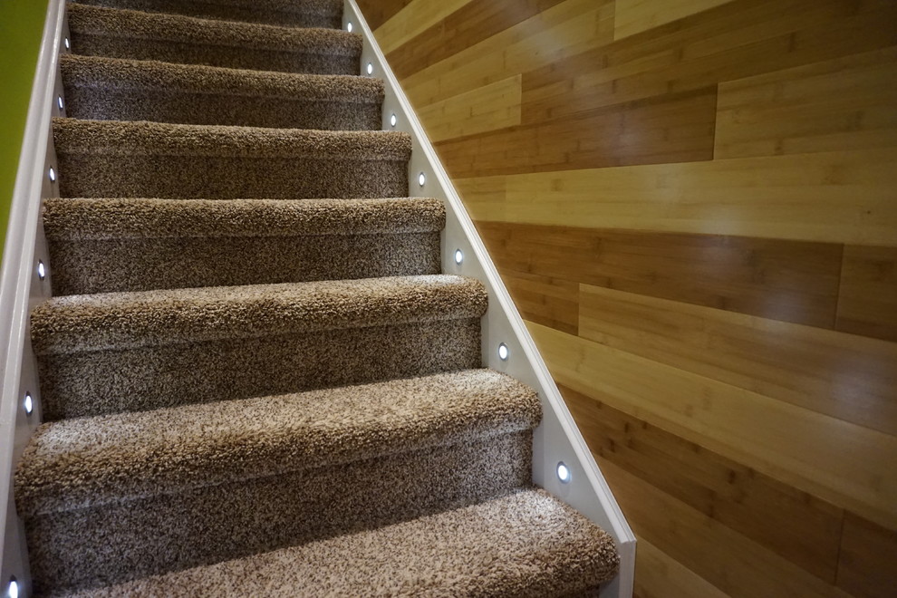 Small modern carpeted straight staircase in Toronto with carpet risers.